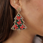 A model wearing the beaded Christmas tree earring, seen in profile.