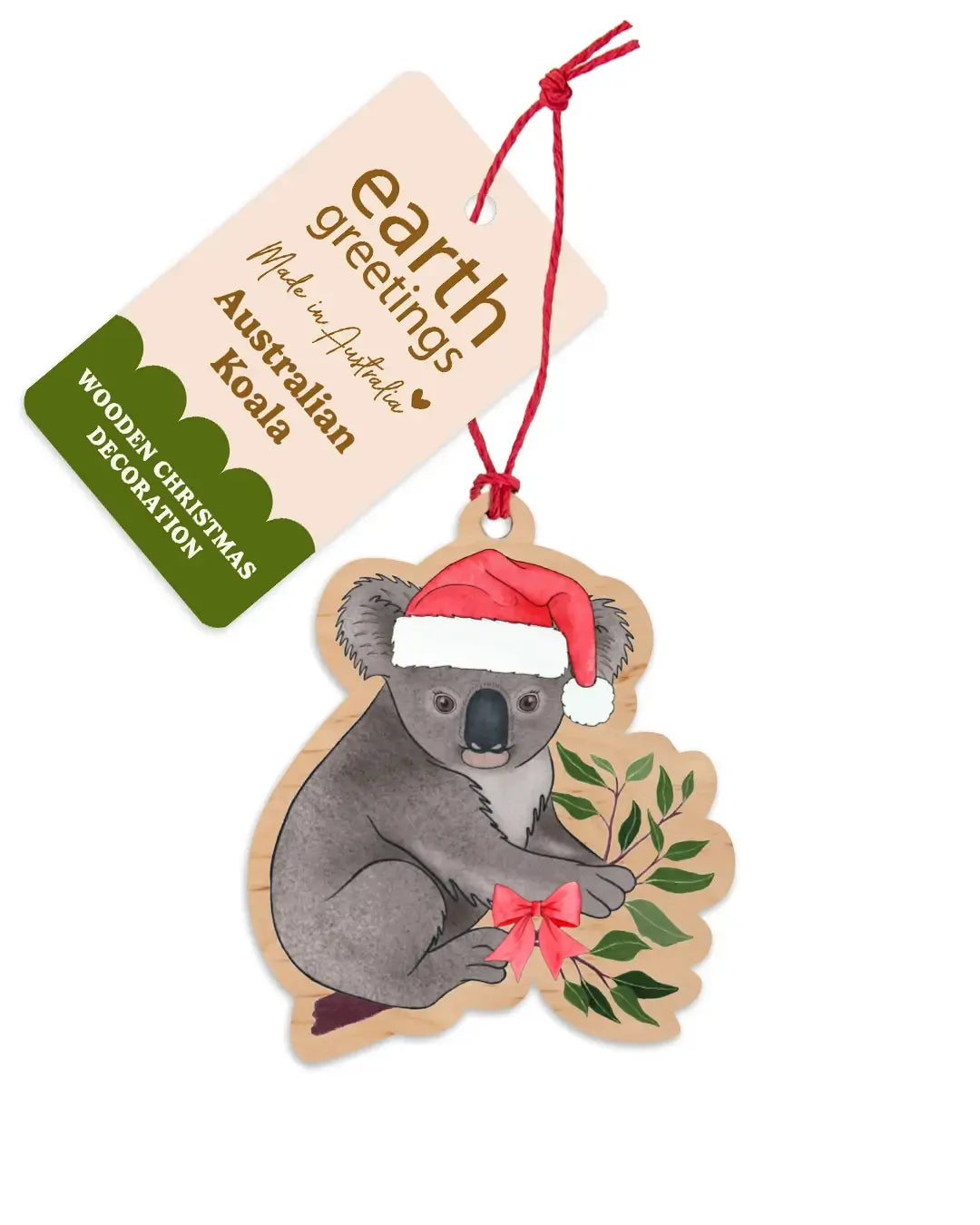 Wooden koala Christmas decoration hanging from a red twine tie beside its Earth Greetings swing tag - a koala in a red Santa hat among eucalyptus leaves with a small red bow.
