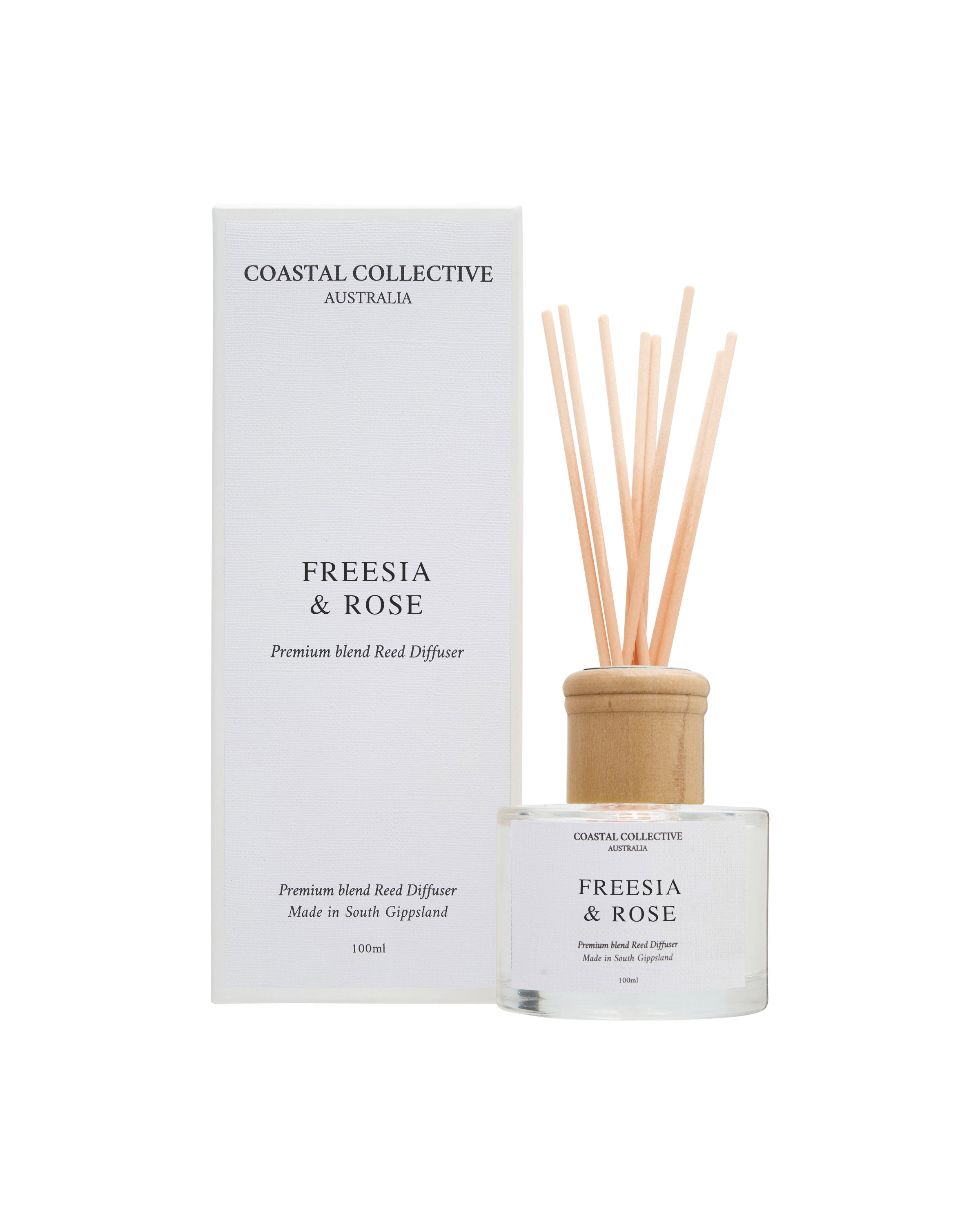 Freesia & Rose reed diffuser, bottle and reeds in front of the matching box.