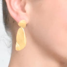 Close-up of the gold layered-drop earring worn on the ear
