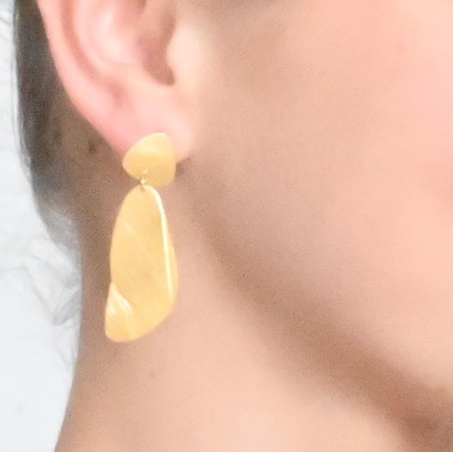 Close-up of the gold layered-drop earring worn on the ear