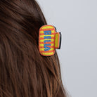 The beaded CIAO claw clip worn in loose brown hair, seen from behind.