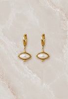 Gold huggie hoop earrings with a white pearl marquise drop set in a beaded gold frame