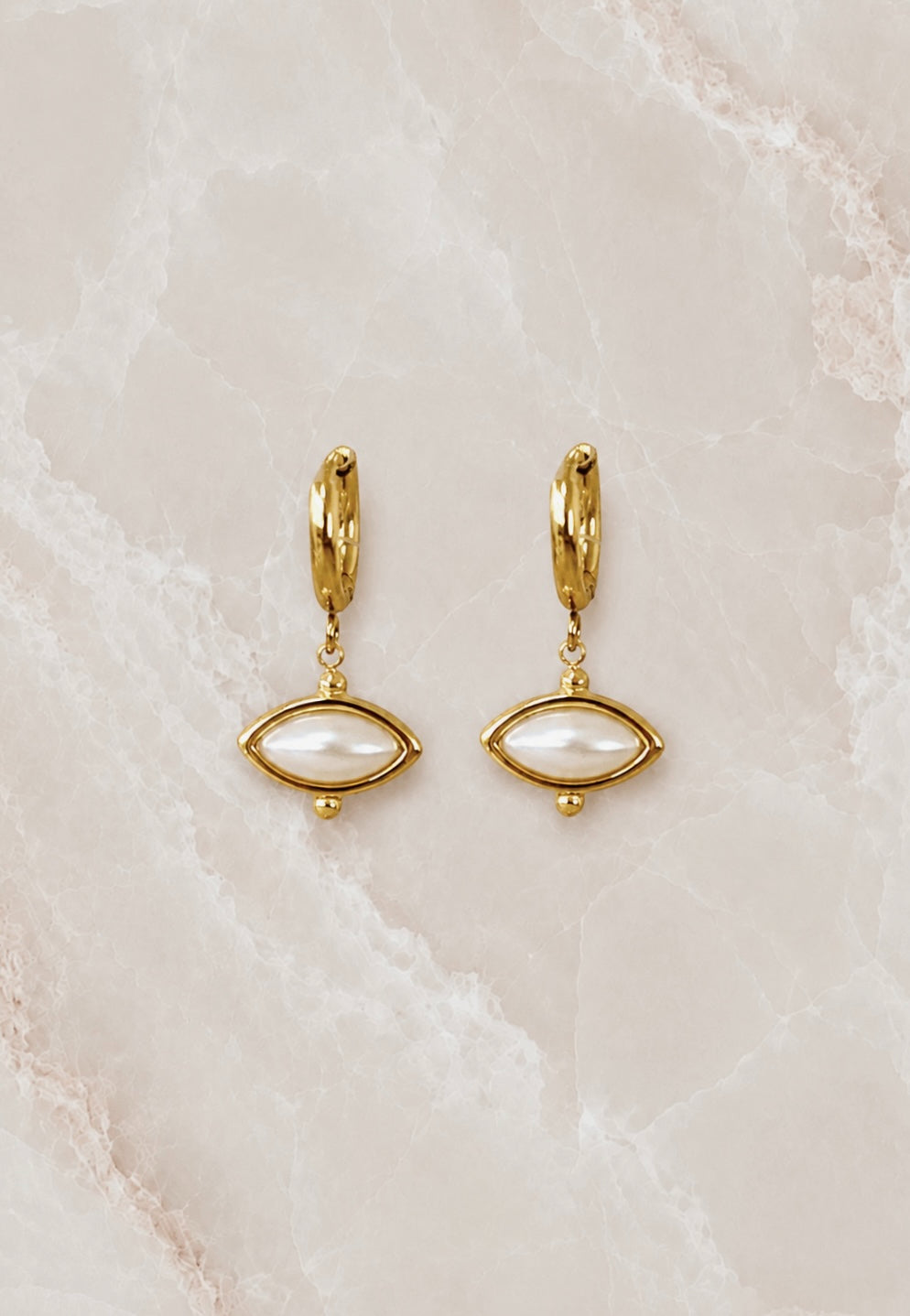 Gold huggie hoop earrings with a white pearl marquise drop set in a beaded gold frame