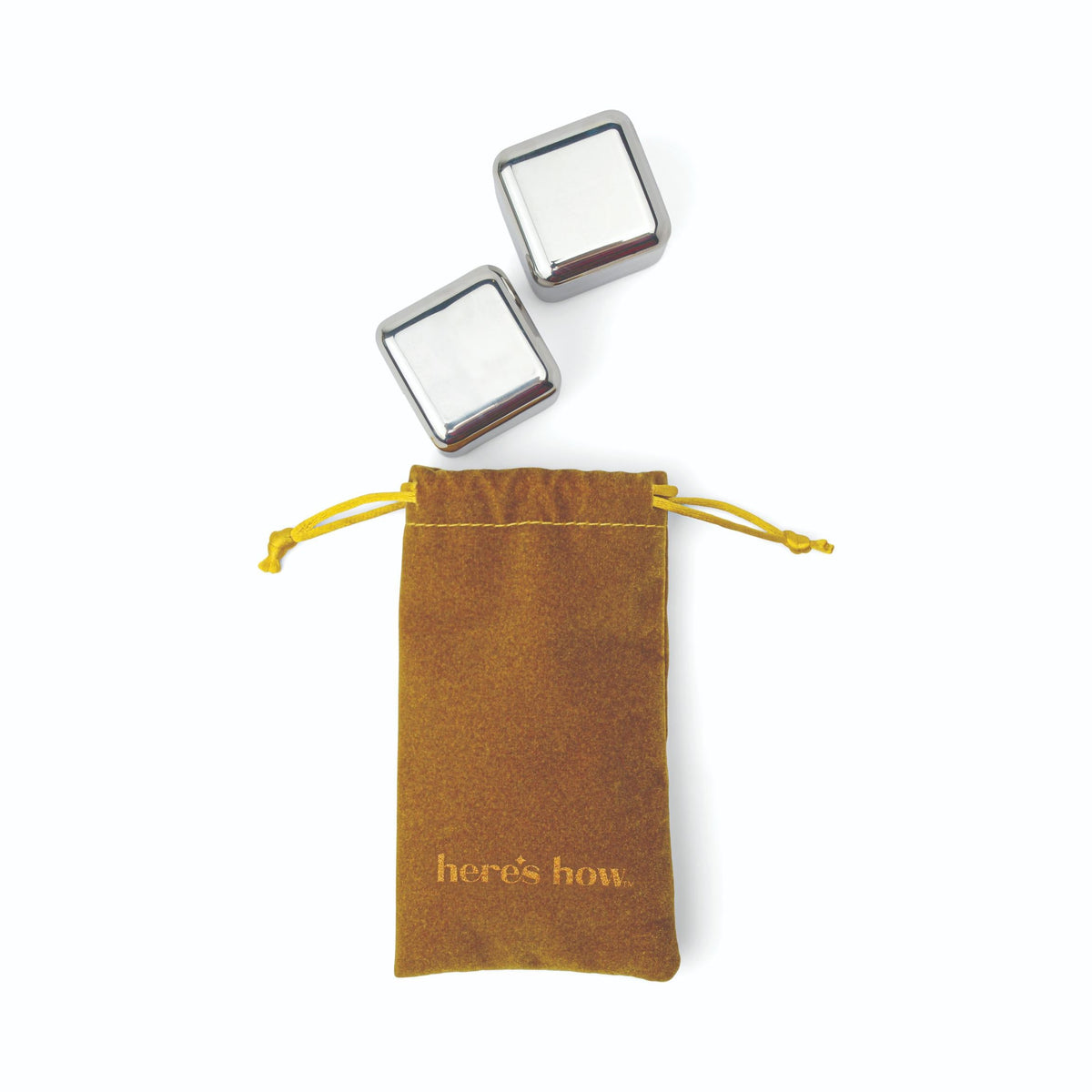 Two silver cubes beside a gold velvet drawstring pouch