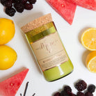 Watermelon Lemonade candle on white with lemon halves, watermelon wedges, blackberries and vanilla pods
