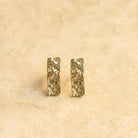 Bella gold earrings on a sandstone surface showing the hammered texture