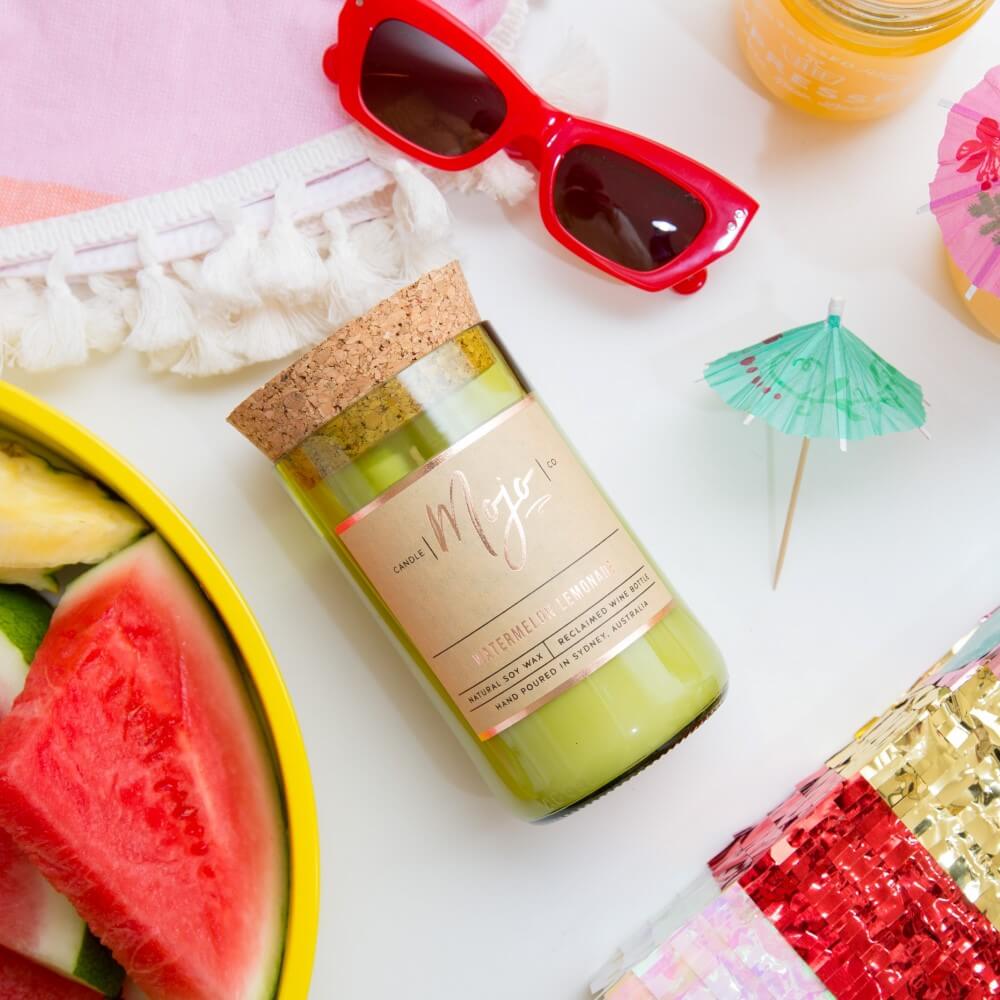 Watermelon Lemonade candle flatlay with red sunglasses, watermelon on a yellow plate and a cocktail umbrella