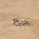 Alaia adjustable sterling silver ring with an organic textured band, on a sandstone surface