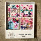 Boxed set of four ceramic magnets with Parisian scenes - perfume bottles, a floral doorway and the Eiffel Tower