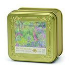 Gold-toned embossed square tin candle printed with Monet's The Artist's Garden at Giverny, labelled Secret Garden soy wax candle, 3.5 oz.