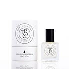 The Perfume Oil Company white gift cylinder beside a 10 ml bottle of perfume oil with a faint golden tint