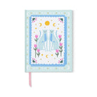 The blue cheetah journal without its band, a pink ribbon marker at the foot
