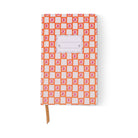 Tulip journal with an orange and white check cover dotted with little pink stars, a blank scalloped label and a tan ribbon marker