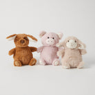 Three plush rattles sitting in a row: a brown puppy with floppy ears, a pink piglet and a cream lamb