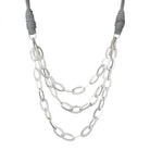 Jireh necklace in silver: three strands of large silver oval links on a tan faux-leather cord