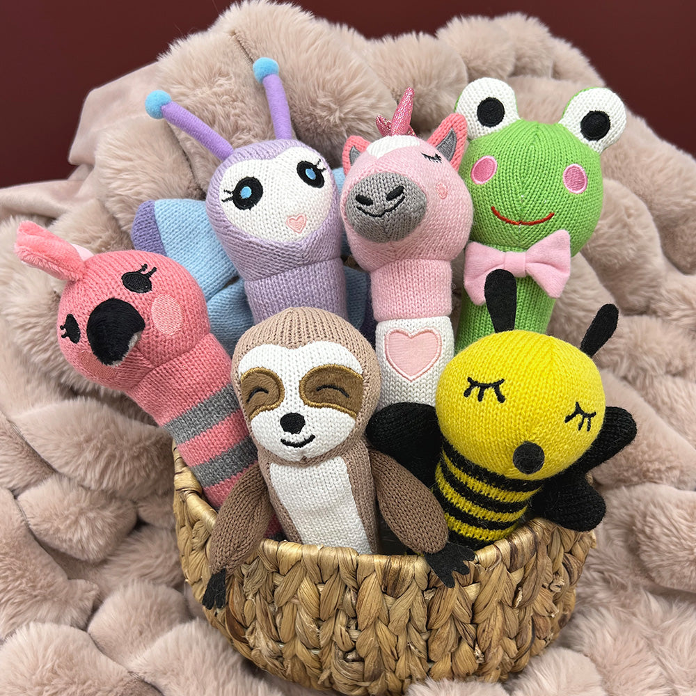 Basket of knit hand rattles including a galah, sloth, bee, unicorn and frog