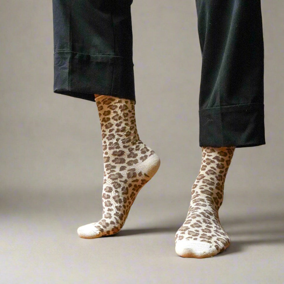 Model in black trousers wearing the leopard print KLUE lurex socks with bare feet