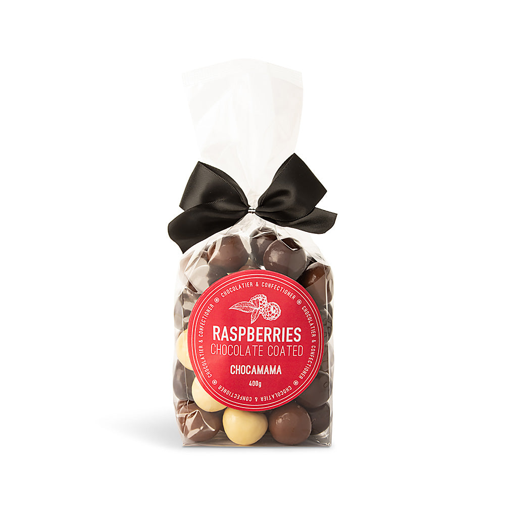 Clear cello bag of milk, dark and white chocolate-coated raspberries tied with a black satin bow, with a round red Chocamama label