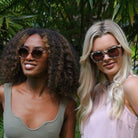 Two women wearing Lila Grace sunglasses side by side, in ivory and champagne