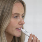 Woman applying Salus Vanilla Lip Balm with the tube's easy-glide applicator
