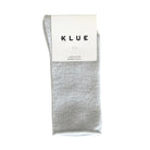 Silvery-white KLUE glitter lurex socks folded in their branded paper band