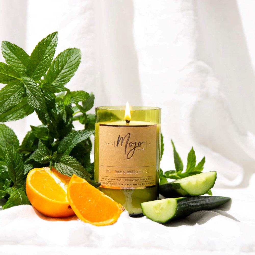 Lit Cucumber & Muddled Mint candle with fresh mint, orange wedges and cucumber slices