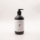 Myrtle & Moss Rose Geranium body lotion in a 500ml amber glass bottle with a black pump and a pale label showing a burgundy sprig.