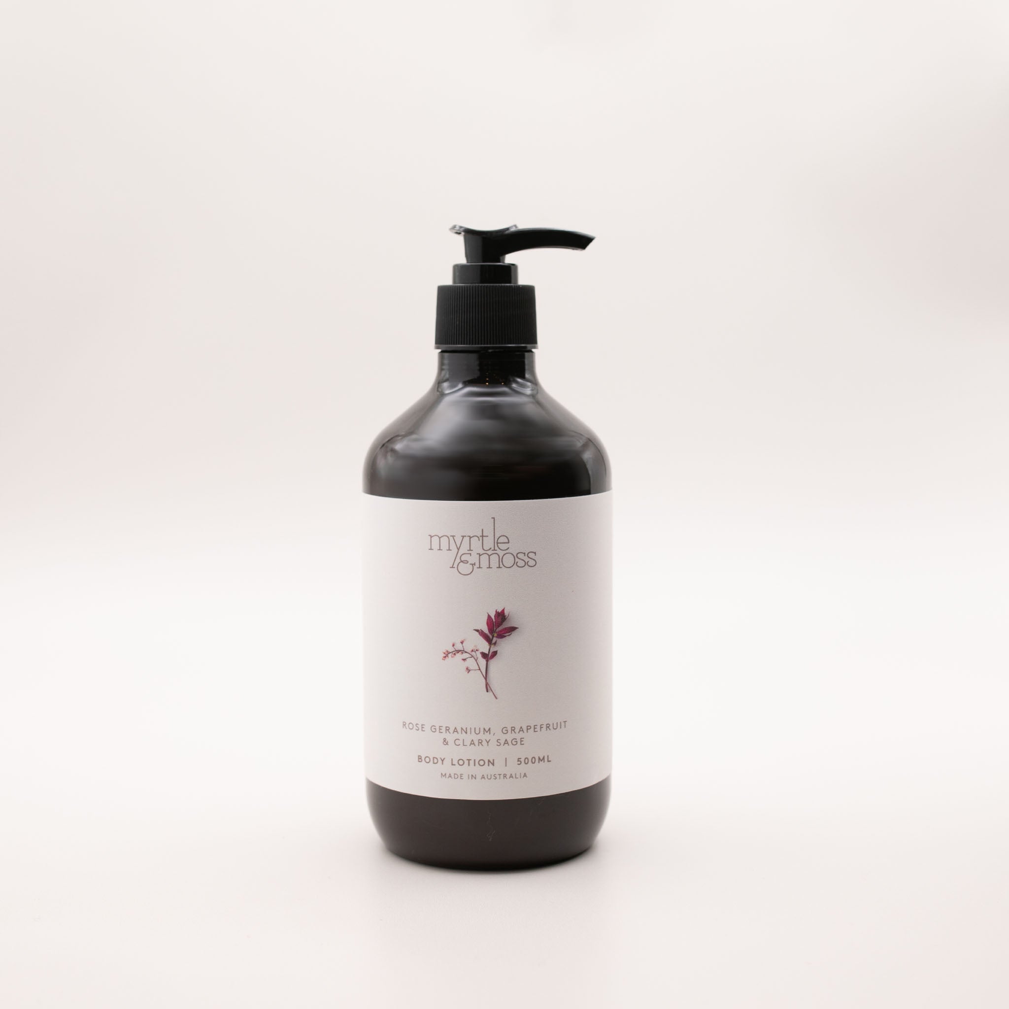 Myrtle & Moss Rose Geranium body lotion in a 500ml amber glass bottle with a black pump and a pale label showing a burgundy sprig.