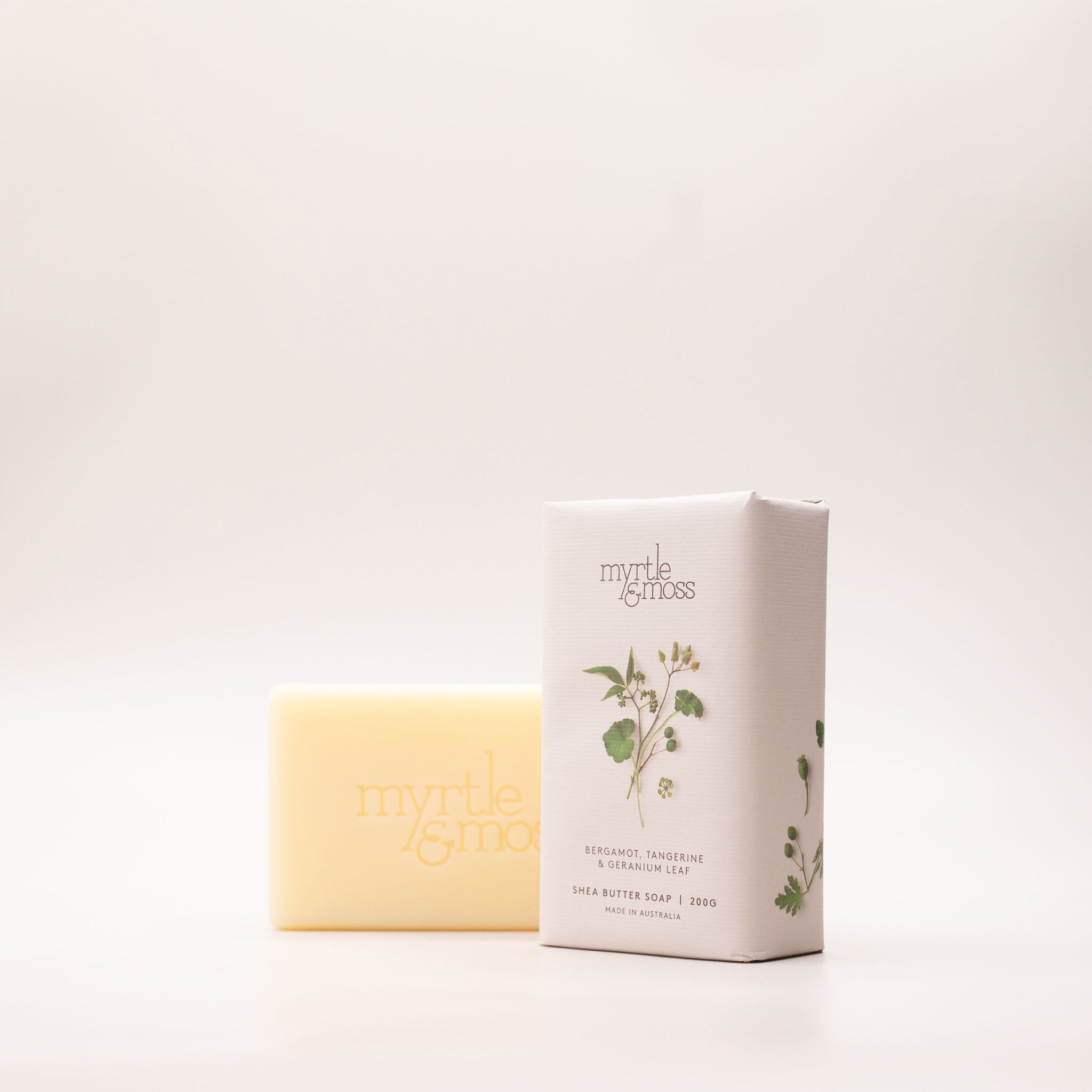 The Bergamot, Tangerine & Geranium Leaf soap box turned at an angle, showing its green botanical print and the 200g label.