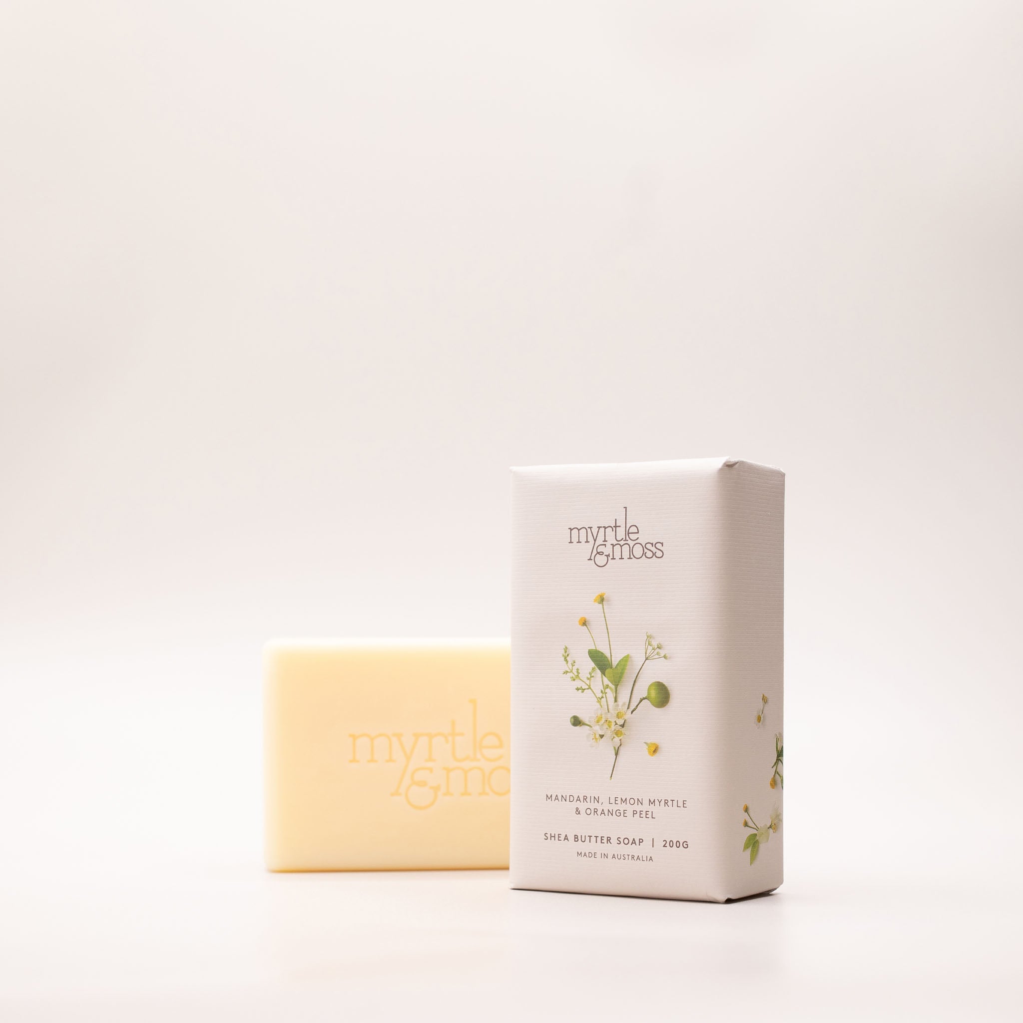 The Mandarin, Lemon Myrtle & Orange Peel soap box turned at an angle, showing its daisy print and the 200g Made in Australia label.