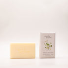 Cream shea butter soap bar embossed 'myrtle & moss' beside its pale grey box, printed with white daisies and yellow buds and labelled Mandarin, Lemon Myrtle & Orange Peel.