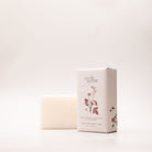 The Rose Geranium, Grapefruit & Clary Sage soap box turned at an angle, showing its burgundy floral print and the 200g label.