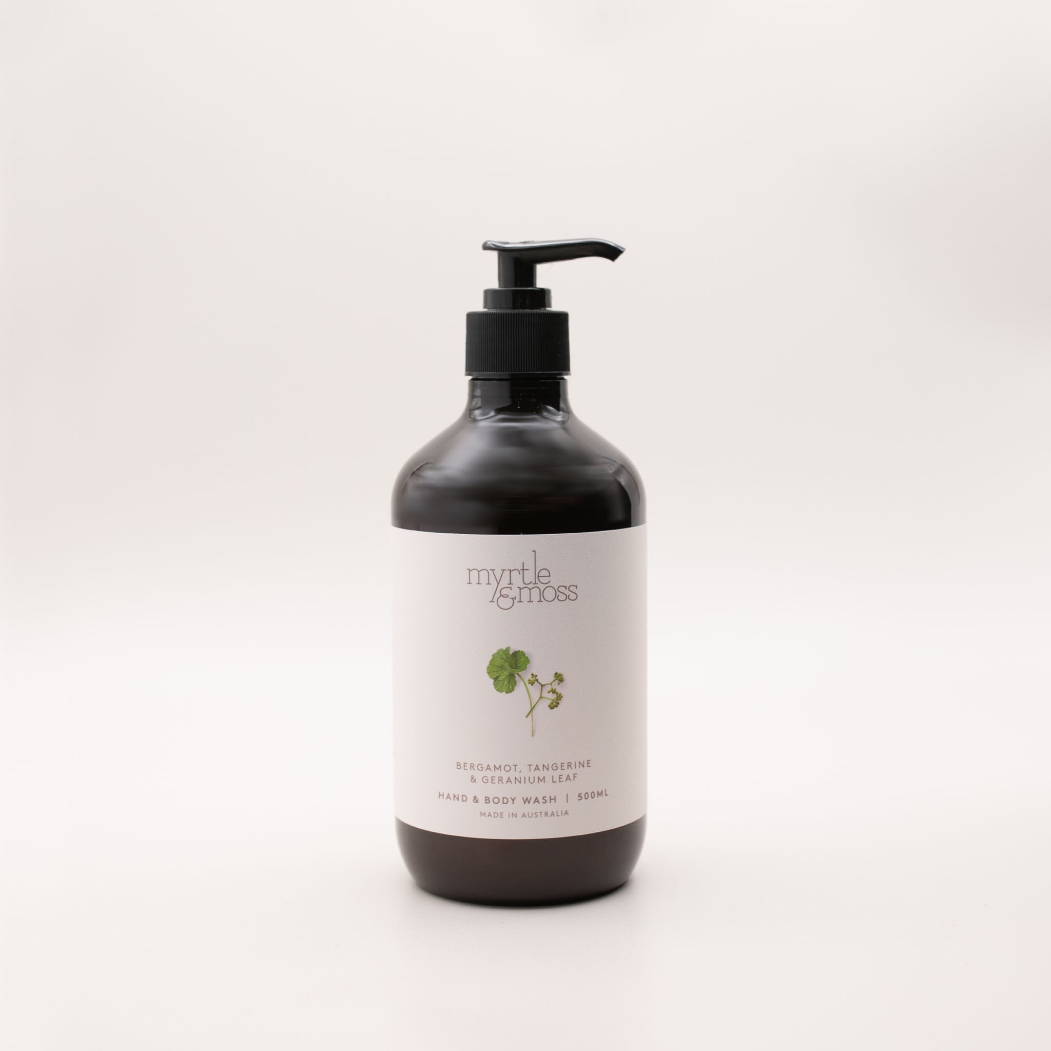 Myrtle & Moss Bergamot hand and body wash in a 500ml amber glass bottle with a black pump and a pale label showing a green geranium-leaf sprig.
