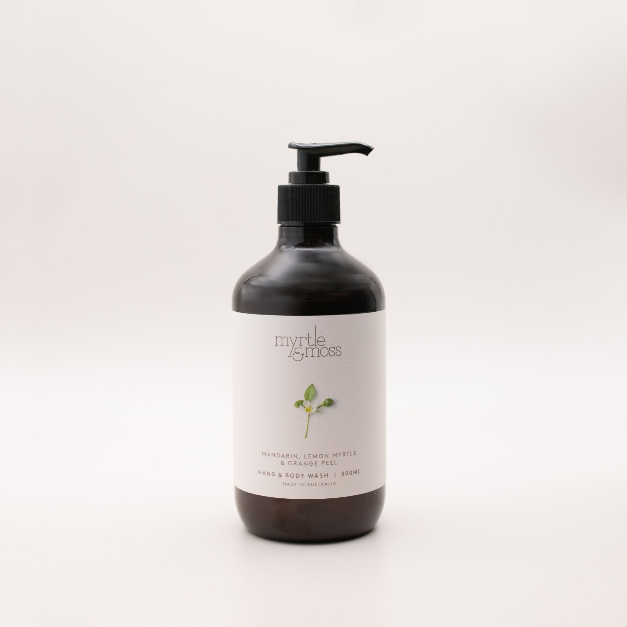 Myrtle & Moss Citrus hand and body wash in a 500ml amber glass bottle with a black pump and a pale label showing a green sprig.