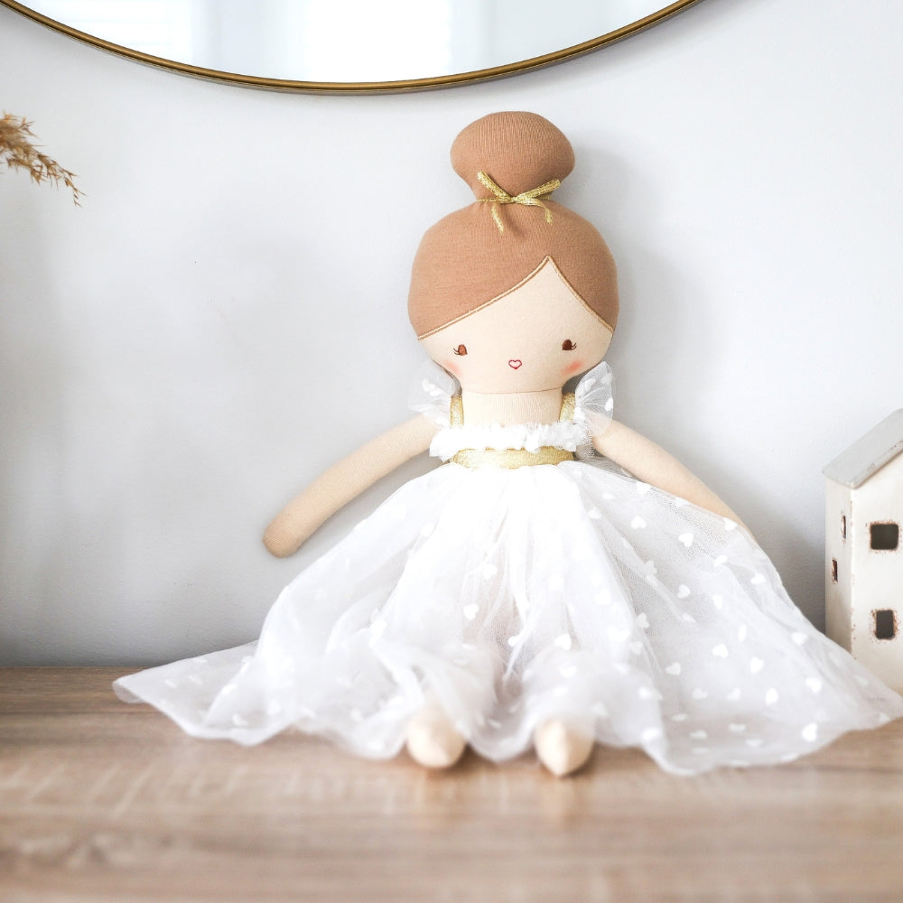 Lottie doll seated on a dresser beneath a round mirror