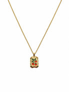 Gold-tone chain necklace with a wavy-edged rectangular pendant showing three red strawberries and green leaves on a cream background