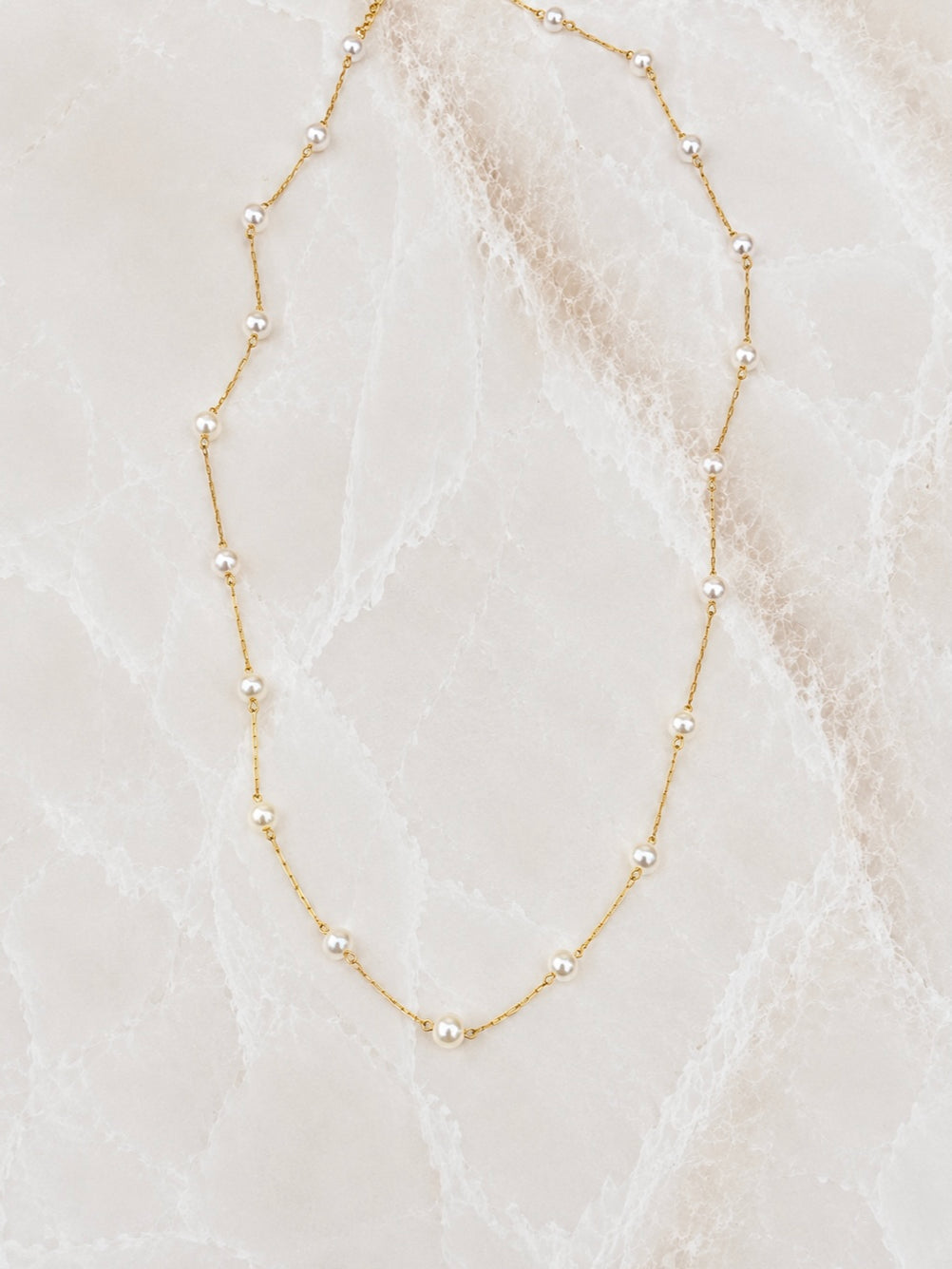 Very fine gold chain necklace with small white freshwater pearls spaced along its length