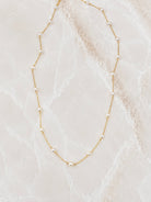 Very fine gold chain necklace with small white freshwater pearls spaced along its length