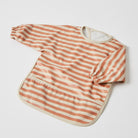 Long sleeve smock laid flat in terracotta and cream stripes, with cream binding, elastic cuffs and a pocket across the hem