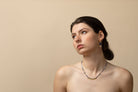 Model wearing delicate Euro Gold drop earrings and a fine beaded necklace