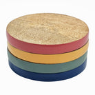 Close-up stack of the four Nikkie coasters showing multi-coloured enamel sides