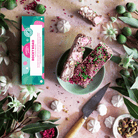 Pebbly Path Pavlova Parkway rocky road 100 g box with two slices on a green plate, mini meringues, pistachios and freeze-dried raspberries