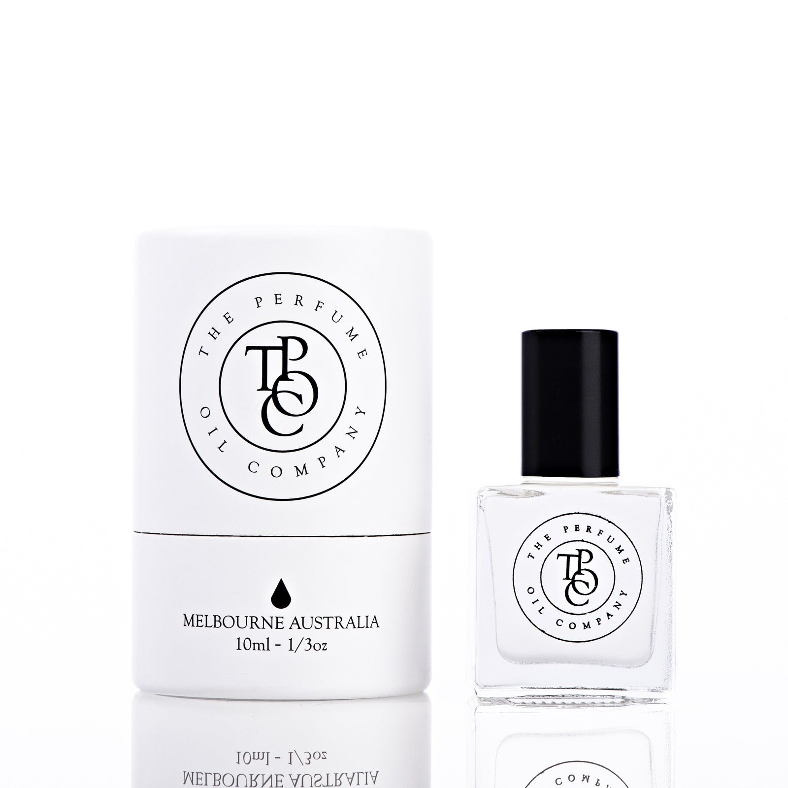 The Perfume Oil Company white gift cylinder beside a 10 ml bottle of perfume oil, studio lit on white