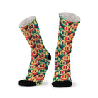 Pair of socks with black toes, printed with rows of retro game controllers in cream, teal and coral on a dark brown ground.