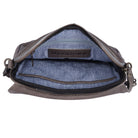 The taupe bag unzipped from above, showing the blue lining and a stamped leather tab