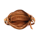 The tan bag unzipped from above, showing the tan lining, inner pockets and a stamped leather tab