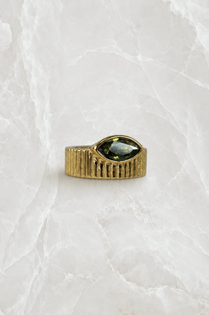 Wide fluted gold band ring with an olive-green marquise stone set flat into the front