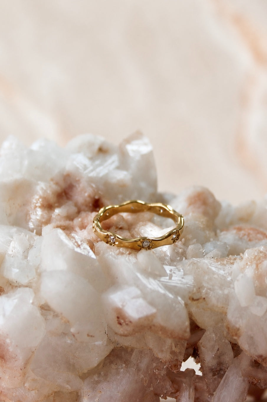 Slim gold band ring shaped in a soft wave and set with small clear stones