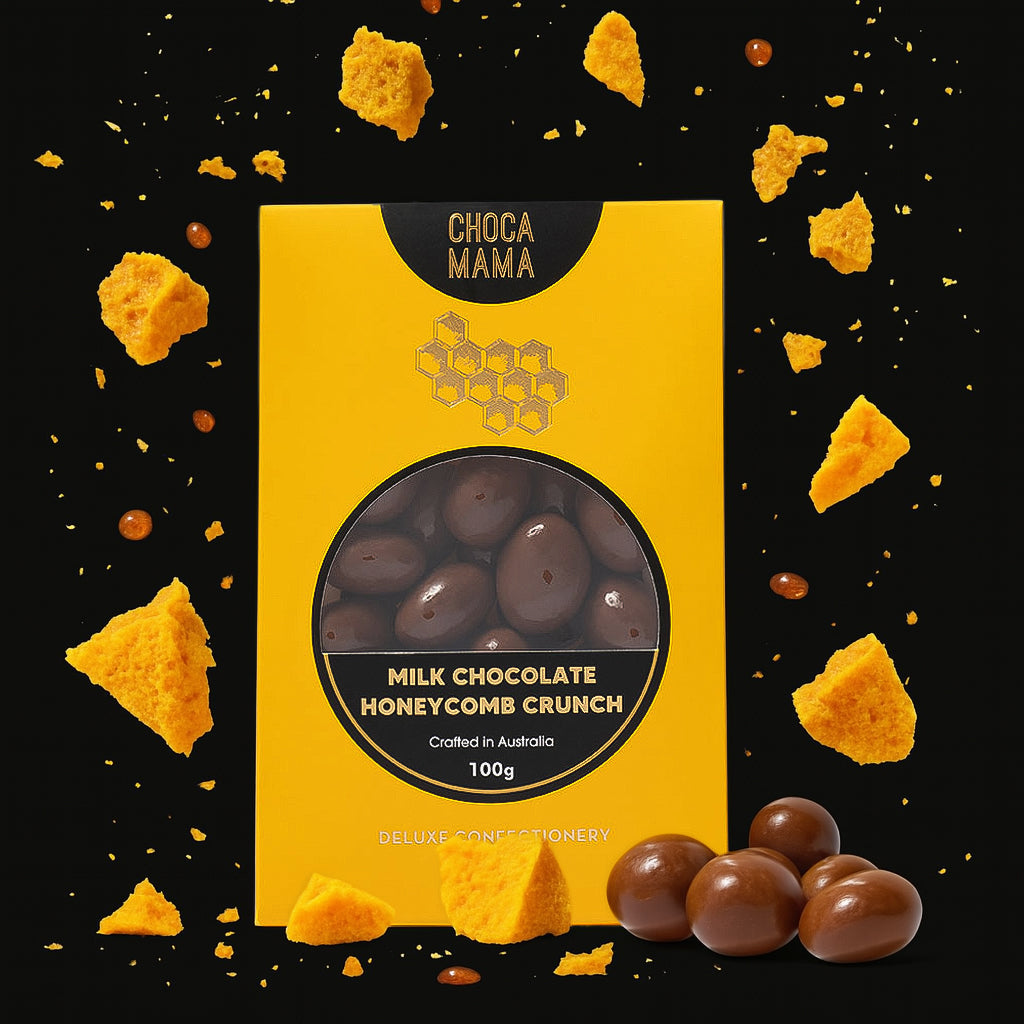 Honeycomb crunch box on black with scattered honeycomb shards and chocolates